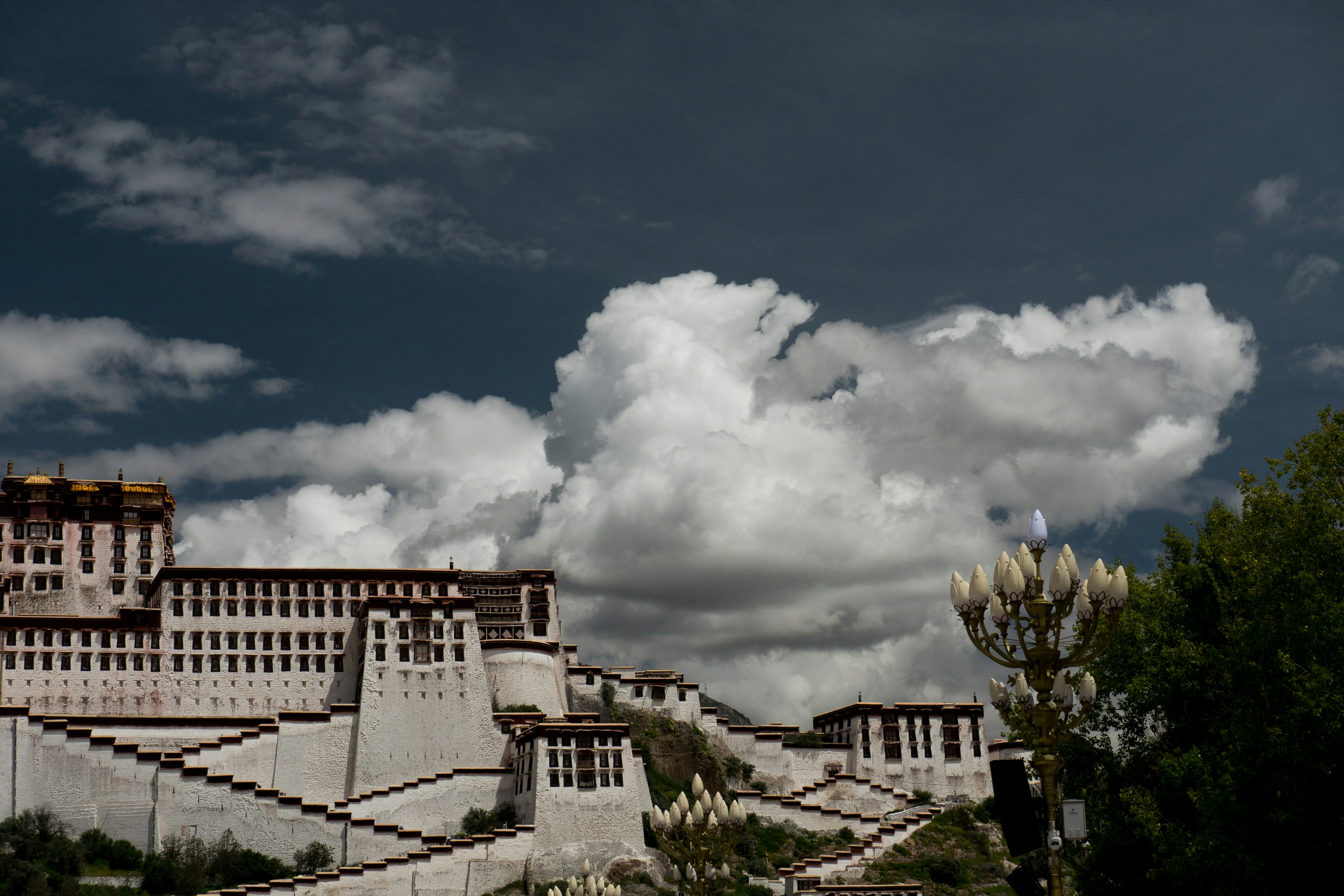 white and brown concrete building under white clouds and blue sky during daytime